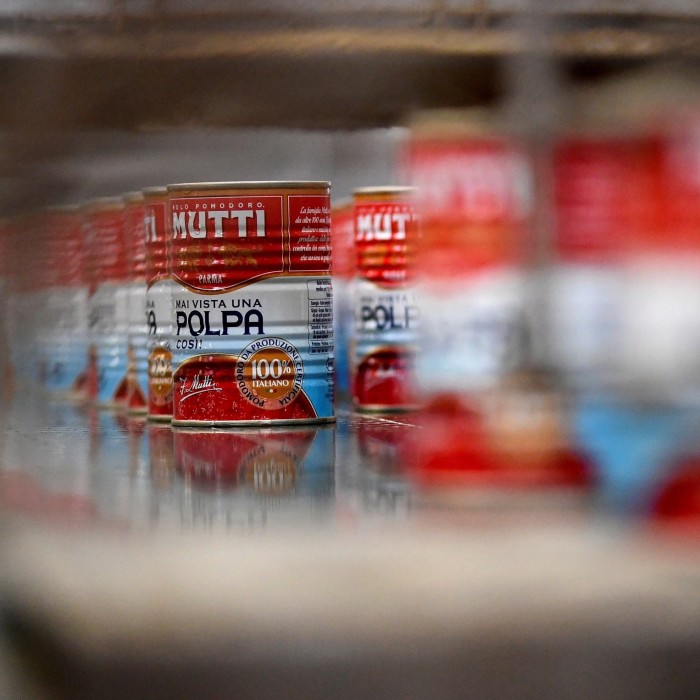 Cans filled with tomato polpa move along the Mutti factory assembly line