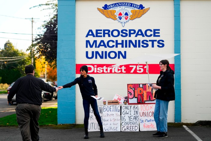 Boeing calibration specialist Eep Bolaño, second from left, and machinist Ky Carlson hand out flyers to other employees arriving to vote 