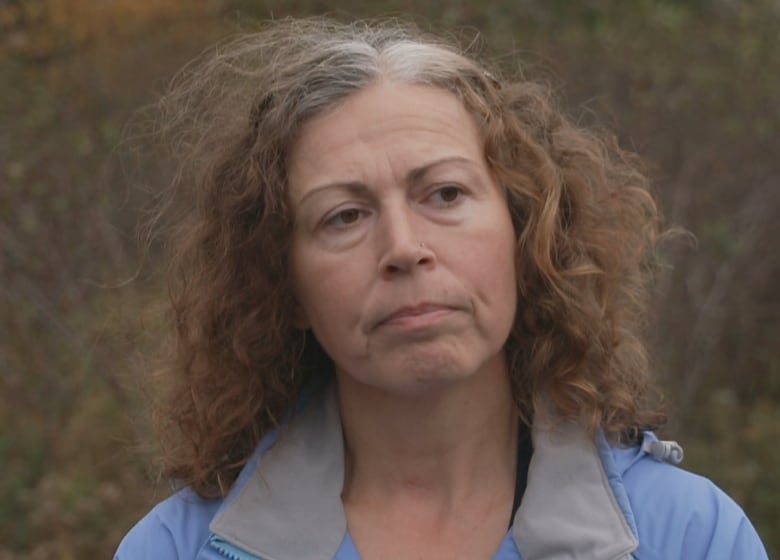 Woman with curly hair in a blue jacket