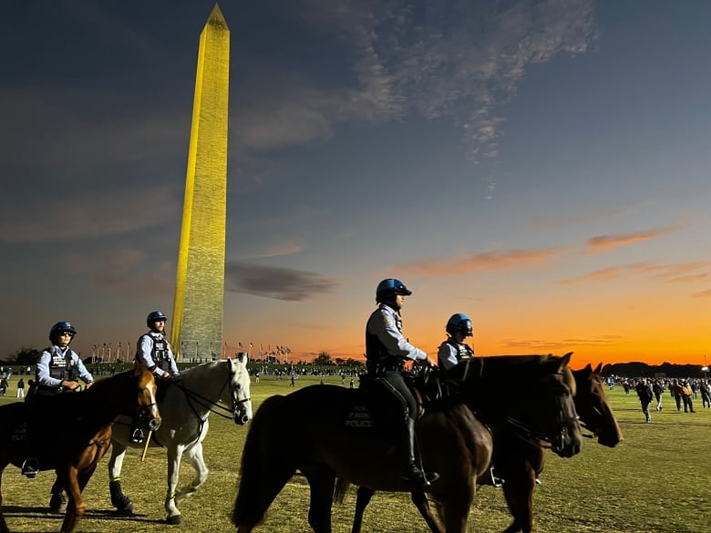 Police on horses at sunset in front of Washington Monument