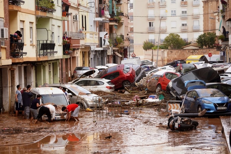 Several cars are shown piled up in a narrow laneway in an urban setting.