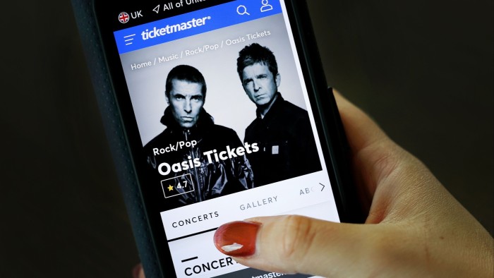 A mobile user looks at Oasis reunion tickets for sale on the Oasis live 25 website