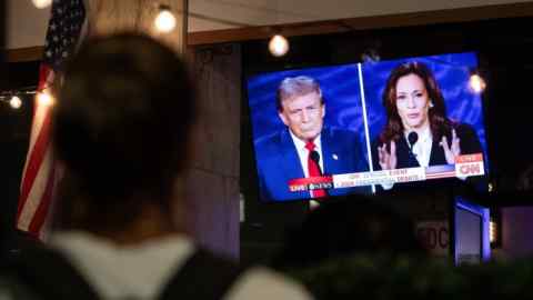 Person views a screen showing Trump and Harris