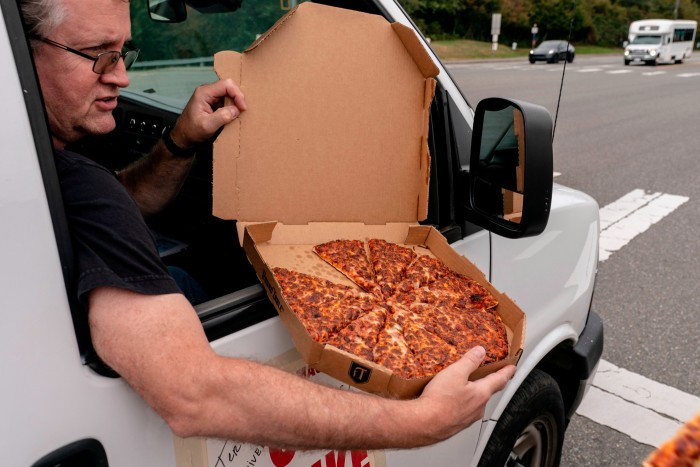 Ken Ogren offers pizza to picketers while riding in a union shuttle as Boeing workers picket outside of the Boeing Everett factory during an ongoing strike in Everett, Washington