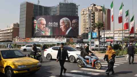 A busy junction in Tehran where people and cars intermingle