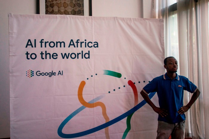 A man stabds in a room in front of a banner that reads: ‘AI from Africa to the world’ 