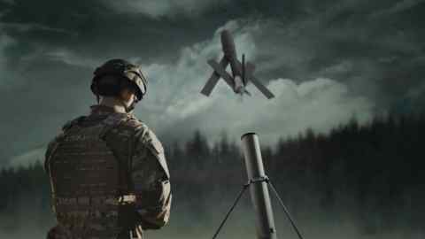 A soldier stands next to the AeroVironment Switchblade drone