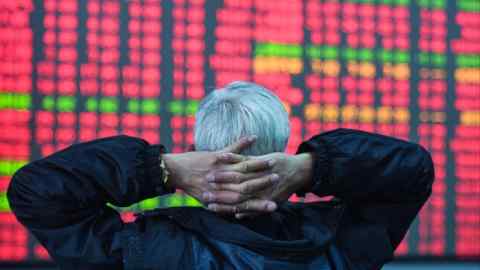 An investor looks at a screen showing stock market movements at a securities company in Hangzhou, in eastern China’s Zhejiang province