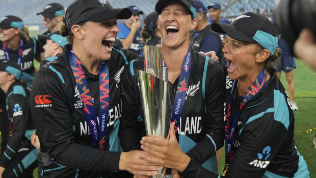 New Zealand's captain Sophie Devine, centre, poses with teammates Lea Tahuhu and Suzie Bates with the trophy after winning the ICC Women's T20 World Cup.