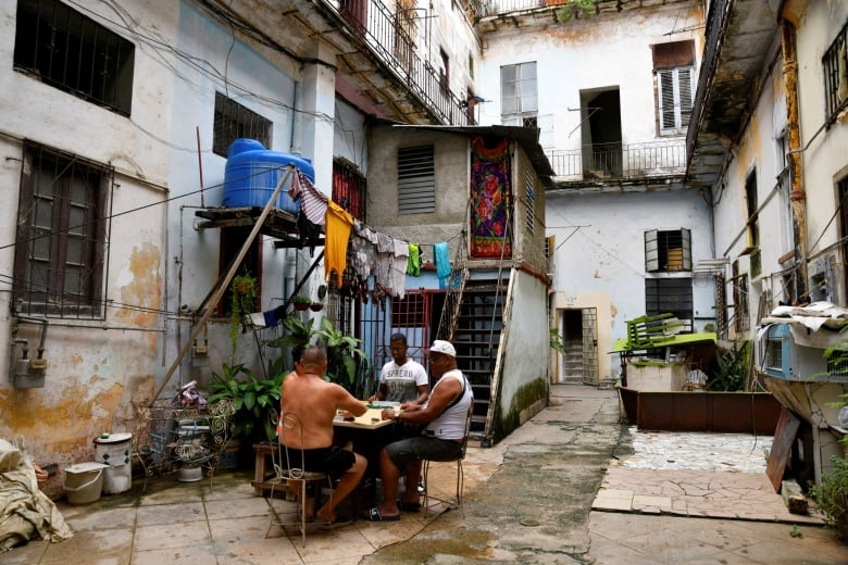 People gather in a courtyard, sitting around a table.