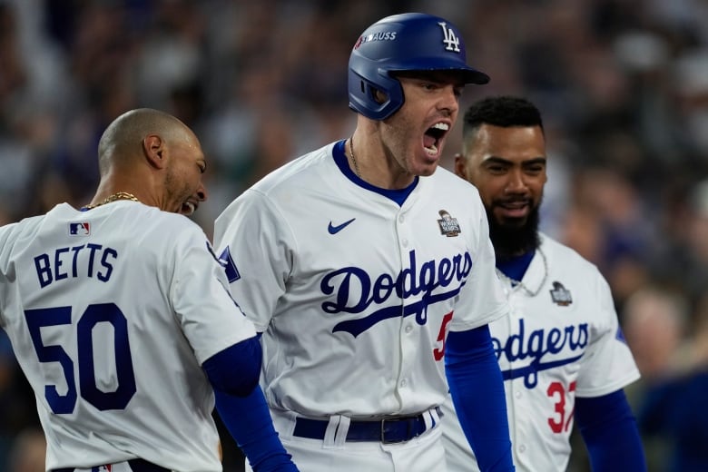 Three Los Angeles Dodgers male players celebrate a home run against the New York Yankees during the third inning on Saturday in in Game 2 of the baseball World Series, Saturday, Oct. 26, 2024, in Los Angeles. (AP Photo/Ashley Landis)