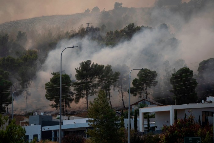 Smoke rises as fire burns in a site next to houses after a rocket, fired from Lebanon, hit a location near the town of Rosh Pinna, northern Israel