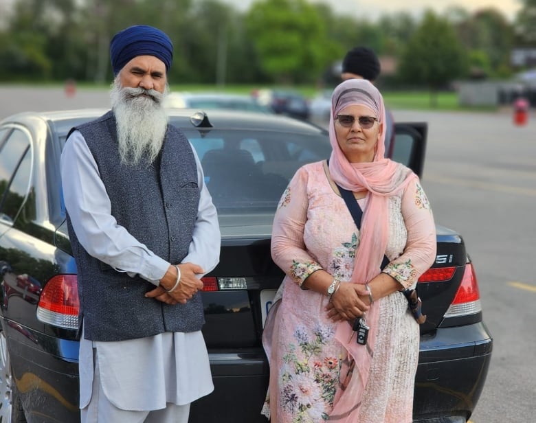 Couple in front of a car