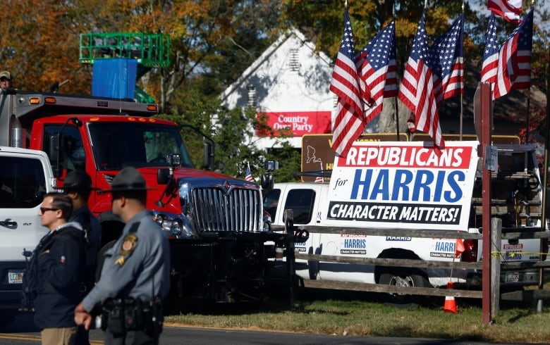 U.S. flags stand on a vehicle with stickers supporting Democratic presidential nominee U.S. Vice President Kamala Harris.