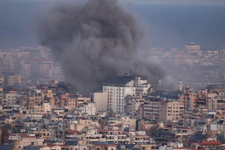 Black smoke billows over a city following an airstrike.