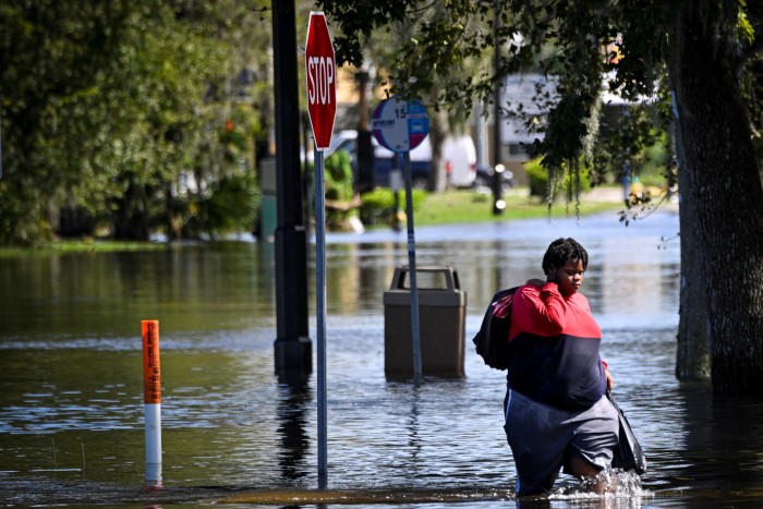 A woman walks through a flooded street in South Daytona, Florida 