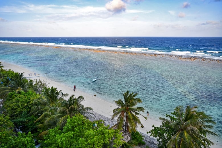 People enjoying a walk on the beach in Hulhumale, on the small island nation in the Indian Ocean, on December 26, 2023. 