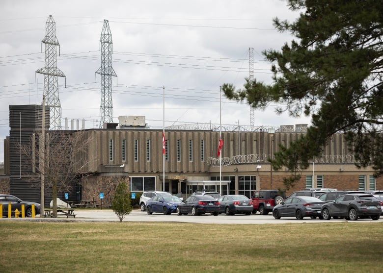 A prison seen from behind its parking lot on an overcast day.