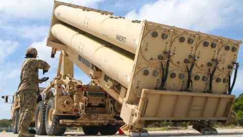 A soldier stands by a missile launcher