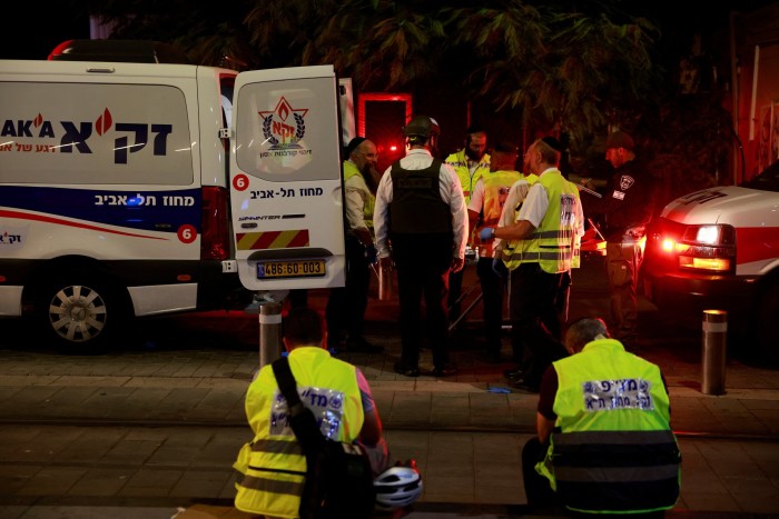 Emergency responders gather around an ambulance