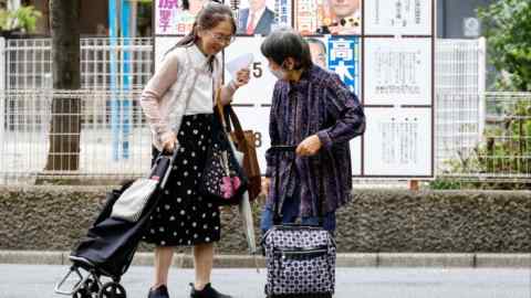 two ladies of a certain age in front of election posters