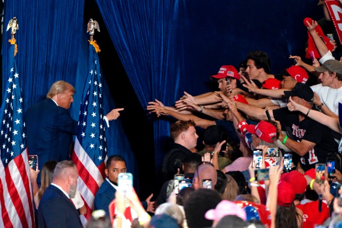 Former US President and Republican presidential candidate Donald Trump gestures at supporters as he exits the stage at the end of a campaign rally at Mullet Arena in Tempe, Arizona