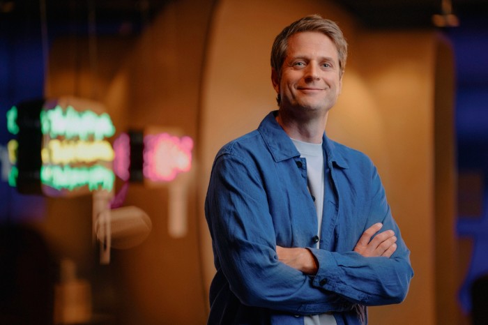 A smiling Sebastian Siemiatkowski is standing with his arms crossed