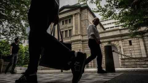 Pedestrians walking in front of the The Bank of Japan headquarters in Tokyo, Japan