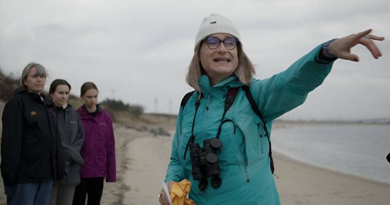 Save Coastal Wildlife's Jenna Reynolds points at a pod of harbor seals swimming in Sandy Hook Bay, New Jersey