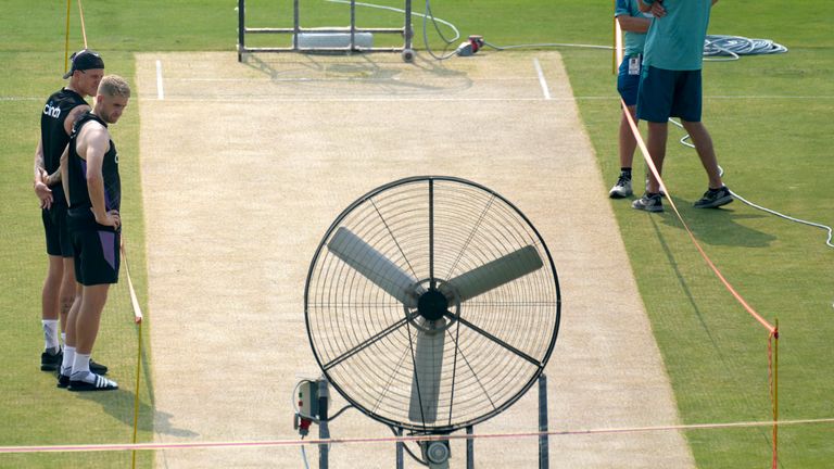 England's Brydon Carse, left, Olly Stone, second left, and Pakistan's coach Jason Gillespie, right, examine the pitch preparing for upcoming third test match between Pakistan and England, in Rawalpindi, Pakistan, Tuesday, Oct. 22, 2024. (AP Photo/Anjum Naveed)