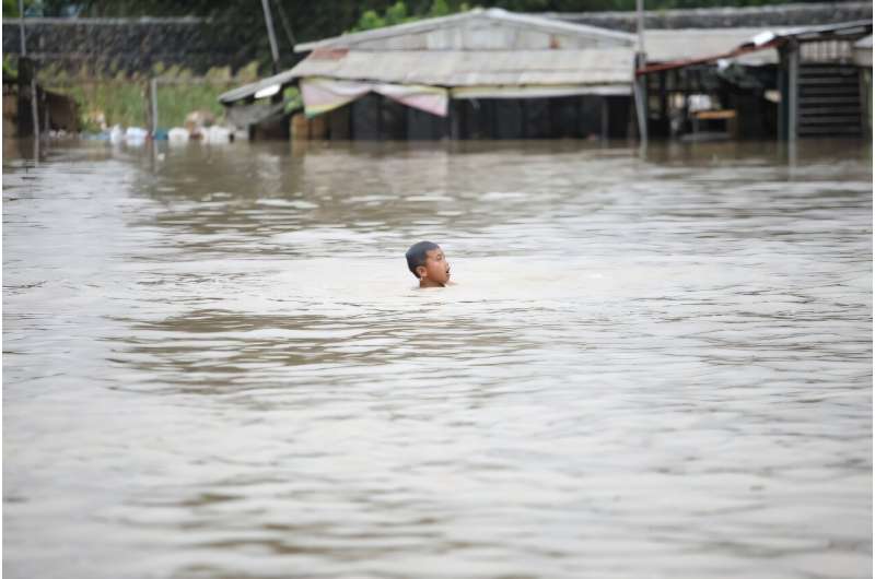 A boy swims near a house flooded by Tropical Storm  Trami in Cagayan province, north of Manila on Thursday