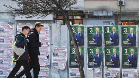 Pedestrians walk past Revival party election posters in Sofia