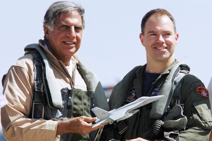 Tata holds a model F-18 while standing next to US pilot Todd Nelson