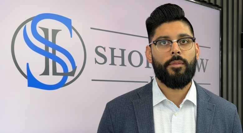 a man in a suit with glasses and a beard.