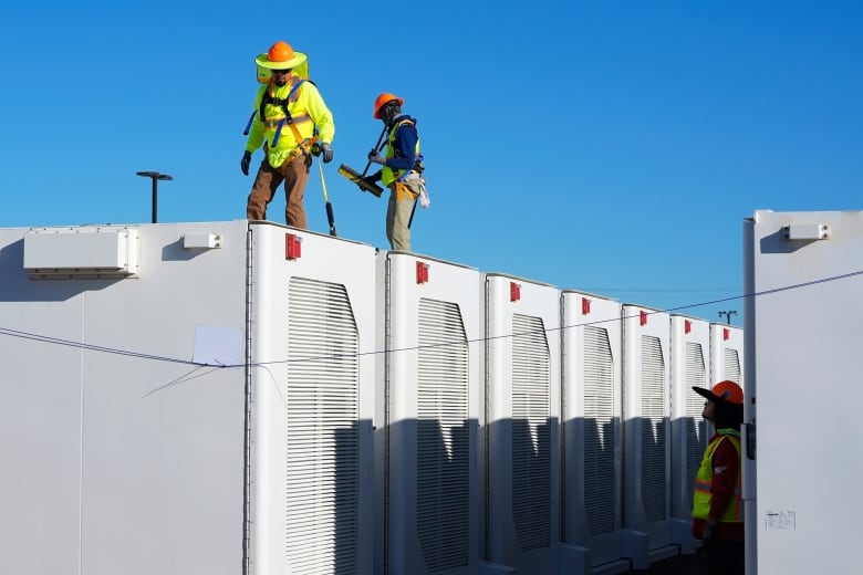 Workers do checks on battery storage pods