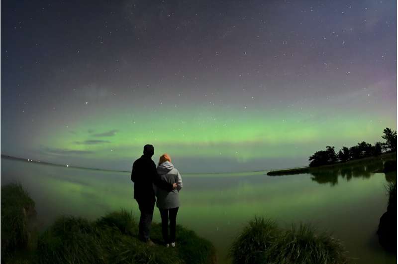 A couple looks out at the southern lights on the outskirts of Christchurch in New Zealand