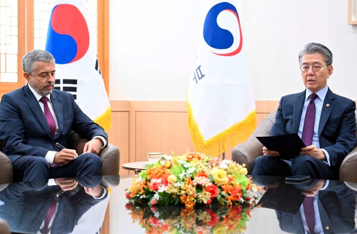 South Korea's vice-foreign minister Kim Hong Kyun, right, is seated across from Russian ambassador to South Korea Georgy Zinoviev during a meeting at the Foreign Ministry in Seoul. Both men are in suits, with a table and floral arrangement between them