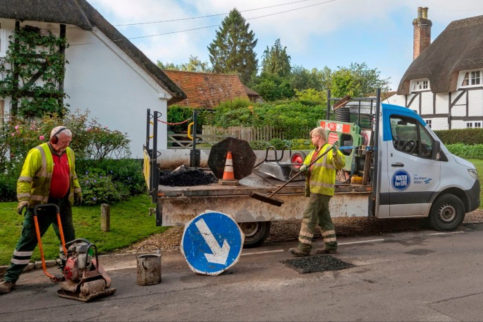 A Southern Water company employee repairing a road surface