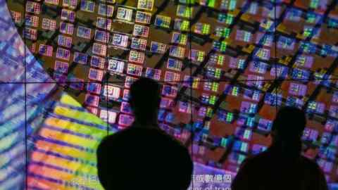 Visitors watch a wafer shown on screens at the Taiwan Semiconductor Manufacturing Company (TSMC) Renovation Museum