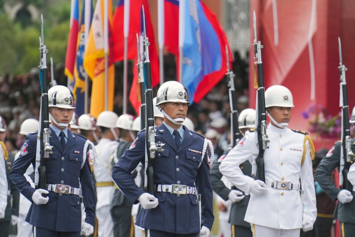 Honour guards in uniform, carrying rifles with bayonets, participate in Taiwan's National Day celebrations in front of the Presidential Office in Taipei