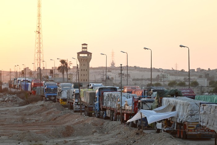 Trucks carrying aid queue on the Egyptian side of the Rafah border crossing with the Gaza Strip