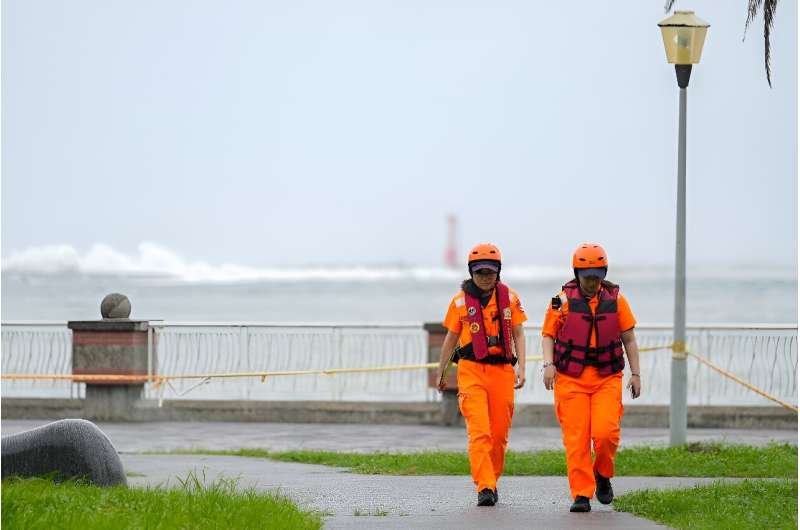 Waves break off Sizihwan Bay beauty spot in Kaohsiung as coast guard officers patrol ahead of the arrival of Super Typhoon Krathon