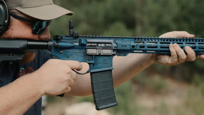 A man firing an assault rifle