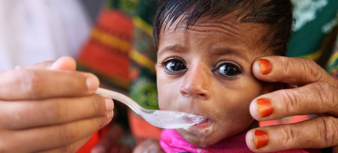 A four-month-old boy is spoon-fed by a staff member at a hospital in Punjab Province, Pakistan.