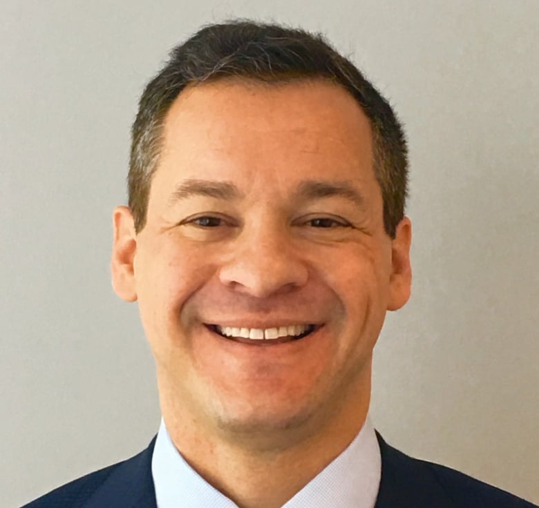 Headshot of a smiling man in a suit 