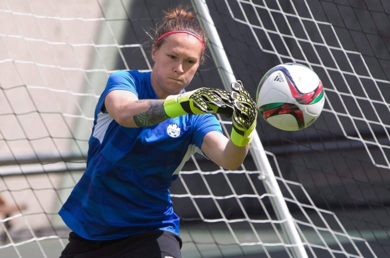 A goalkeeper saves a ball