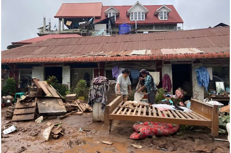 People clean up after major flooding in Kalaw township in Myanmar's southern Shan state on September 19, 2024, following heavy rains in the aftermath of Typhoon Yagi