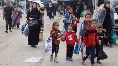 Palestinian families arrive in Gaza City after evacuating their homes in the Jabalia area