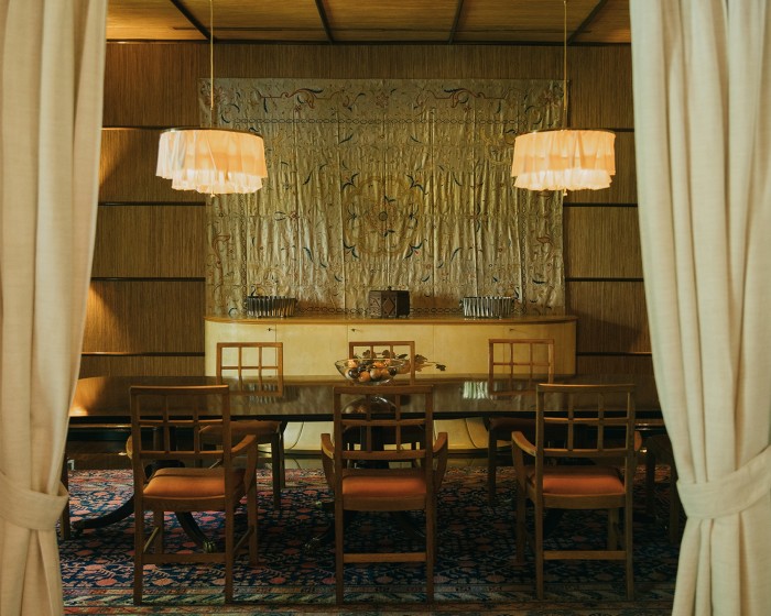 Woka ceiling lamps, a Victorian table, vintage English chairs and an Uzbekistan tapestry on the straw-clad wall in the dining room