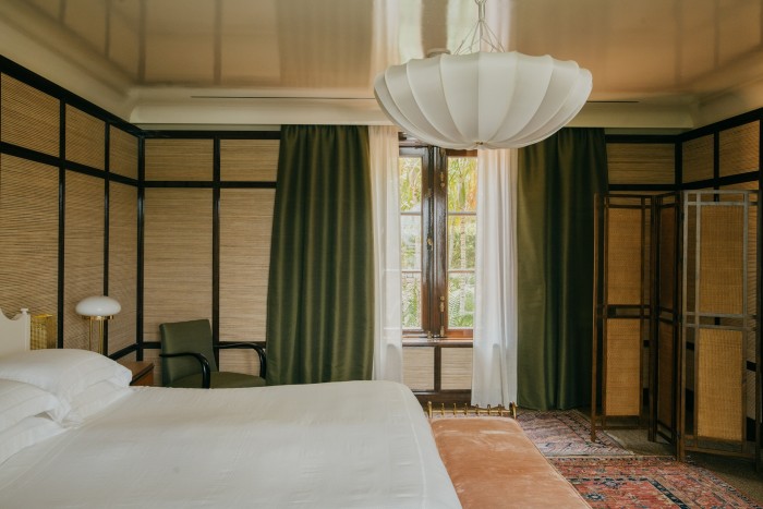 Straw-clad walls, a Woka bedside lamp and a Paolo Buffa chair in the main bedroom